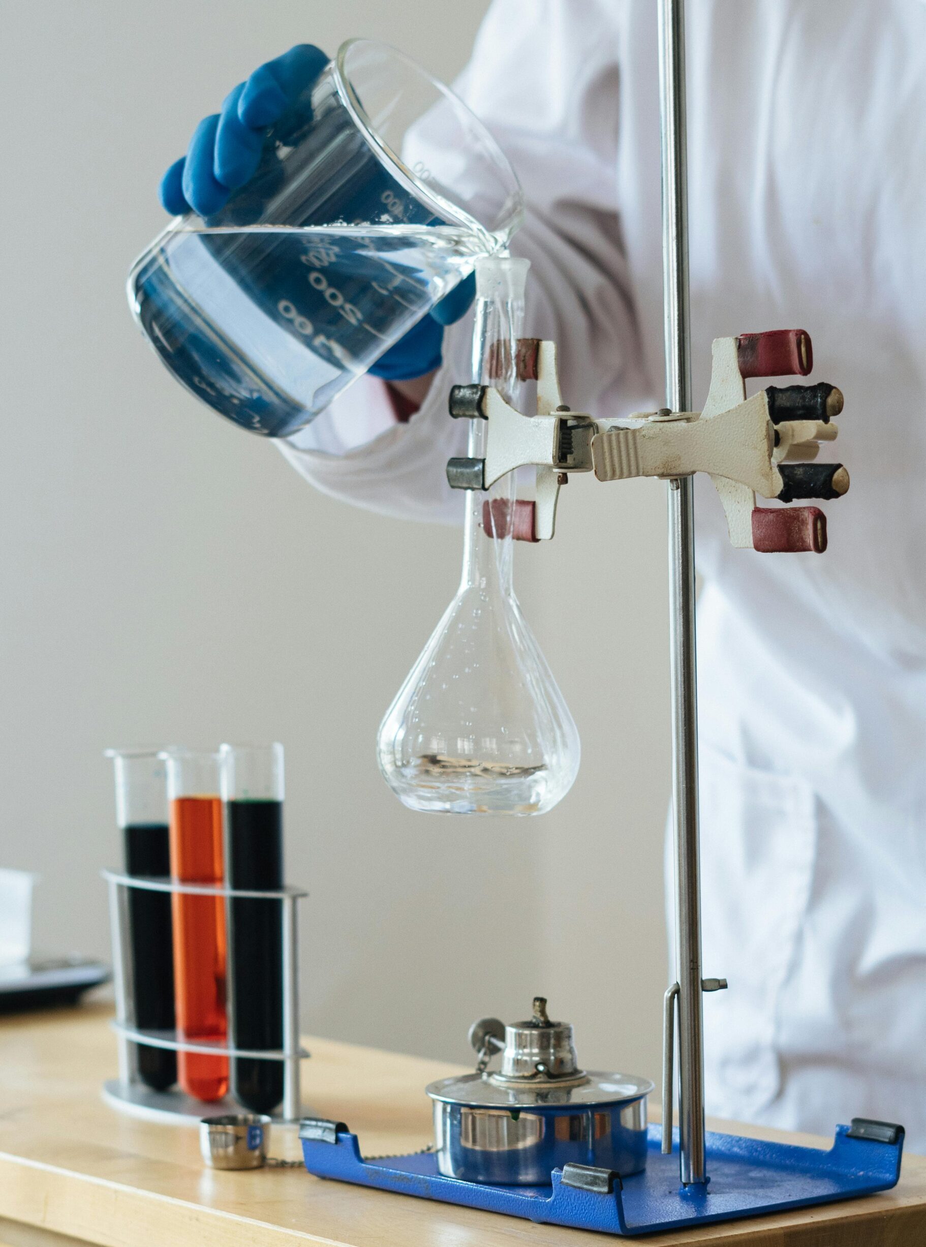 Scientist pouring liquid into a flask in a laboratory setting for research.